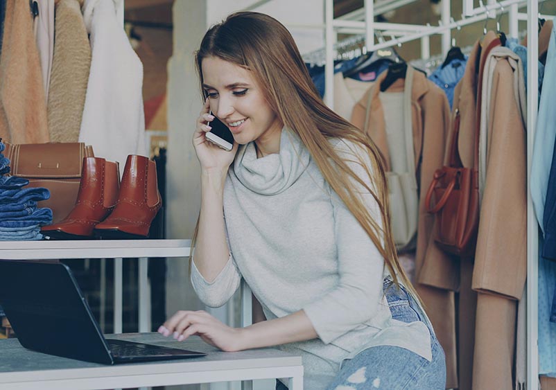 Business owner speaking on the phone while working at a laptop